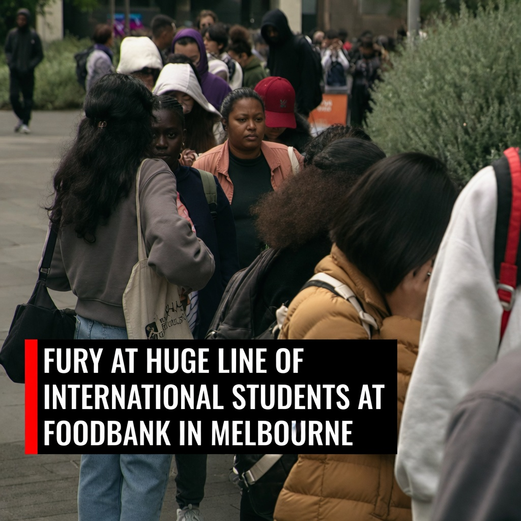 A dense crowd of international students standing in a long foodbank line on a Melbourne university campus